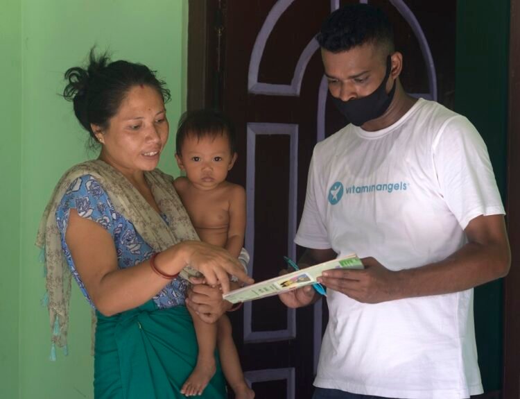One-year-old Ashriya Debbarmas mother Jharna Debbarma shows Ashriyas health card to Vitamin Angels Indias Swapan Kumar Das, Sr. SPO, at Ashriyas home, in village Bishramganj, Sepahijala district, Tripura, India. VAs Swapan K Das along with Dr. Neha Sareen, Monitoring and Evaluation Specialist (not in the photo) visited the families of the Vitamin A beneficiaries with State Government of Tripuras Asha Worker* as part of their monitoring and evaluation. Photo Release no. IN21-R312 Photo by Rohit Jain for Vitamin Angels India *Asha - An accredited social health activist (ASHA  Community Health Worker)