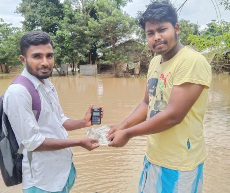 A flood affected victim receiving cash out of PayNearby's Micro ATM